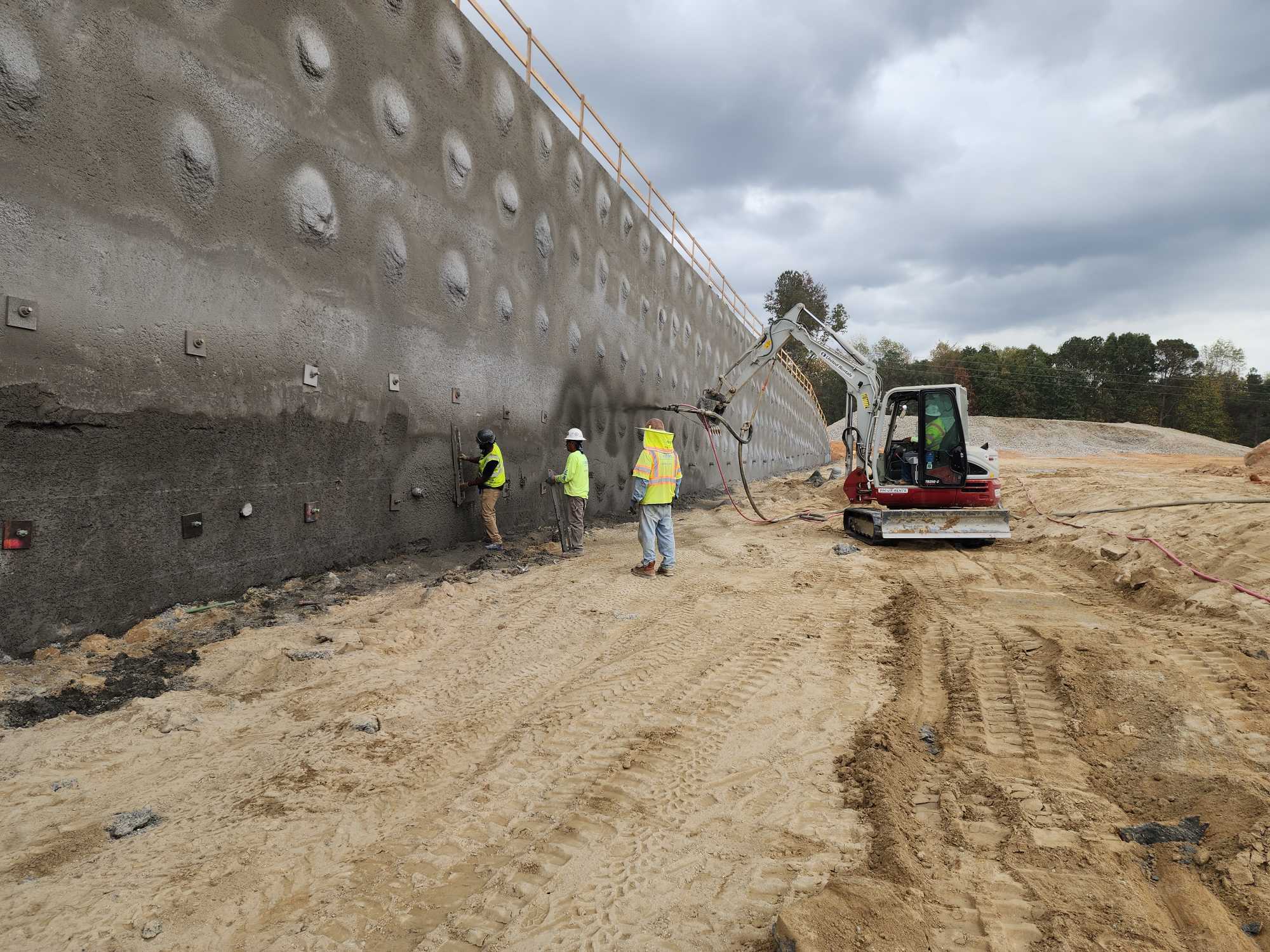 Spraying Shotcrete with a Mini-Excavator Attached Nozzle shotcrete
